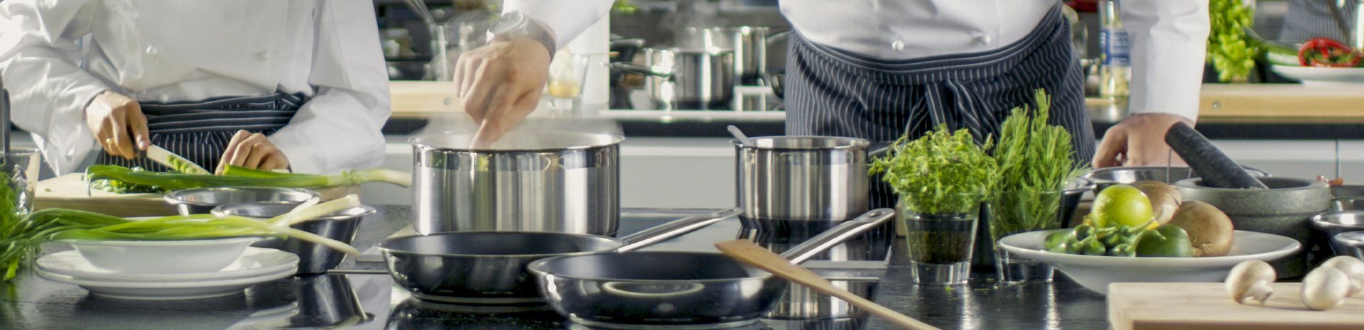 Chefs preparing fresh ingredients and cooking in a modern kitchen | MSC Cruises Chefs preparing fresh ingredients and cooking in a modern kitchen | MSC Cruises